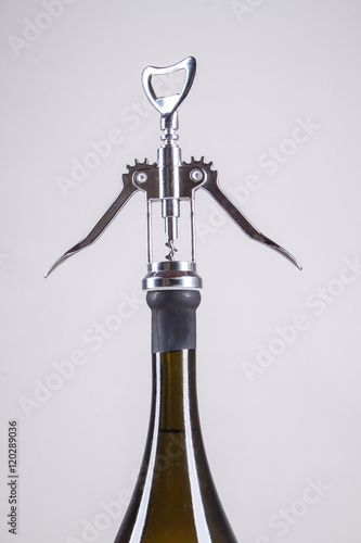 bottle of white wine and a corkscrew for wine