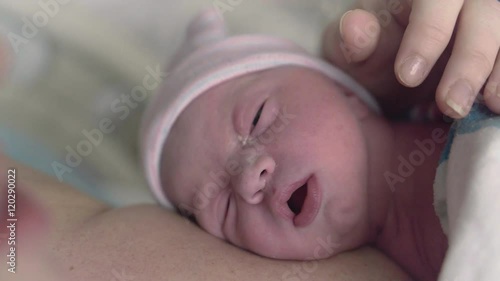 Macro Shot of Newborn Baby in Hospital Laying on Mothers Chest Licking Lips Before First Feeding