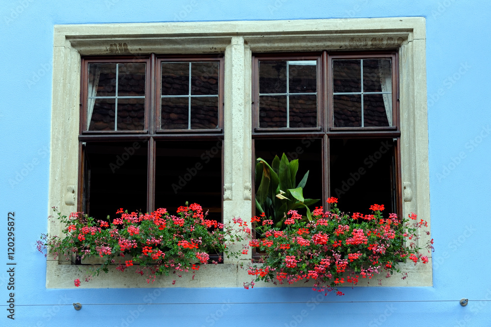 An old house window decorated with flower pots. An old house window decorated with flower pots.