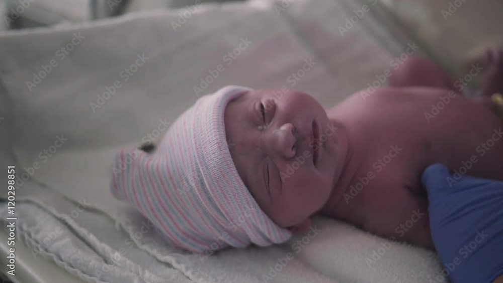 Nurse Puts Stocking Hat on Newborn Newborn Baby Girl Just Born in
