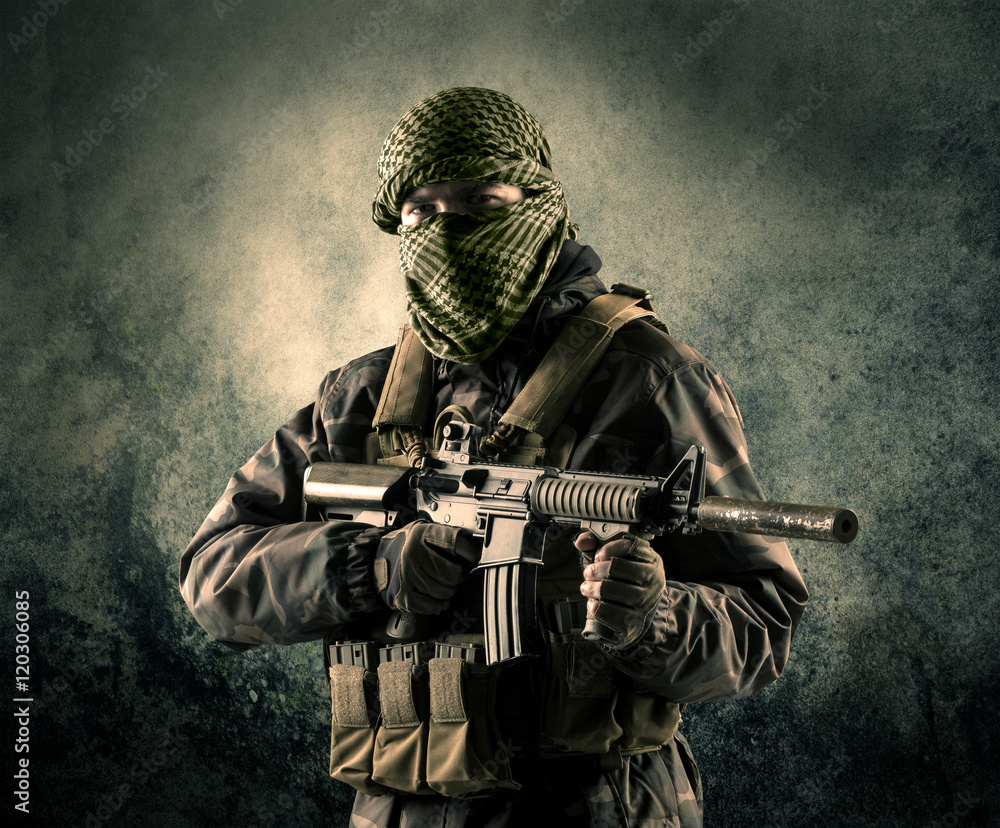 Portrait of a heavily armed masked soldier with grungy backgroun Portrait of a heavily armed masked soldier with grungy backgroun