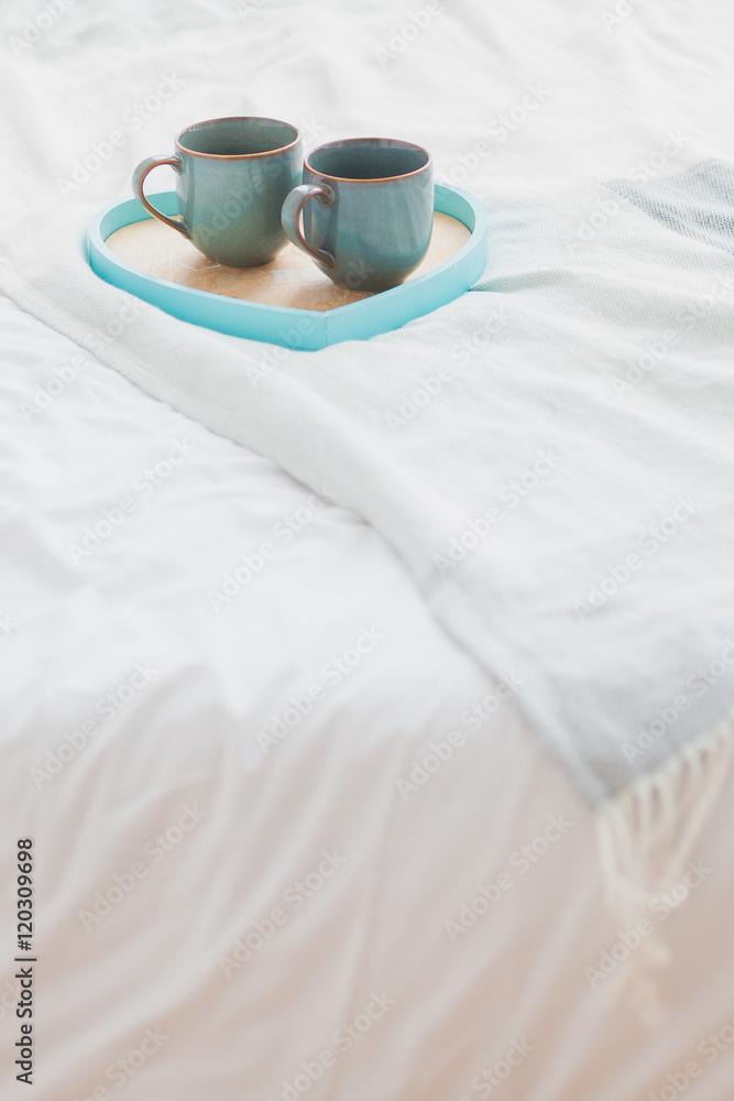 Two mugs on a tray white bed, breakfast concept Two mugs on a tray white bed, breakfast concept