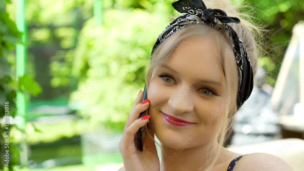 Girl wearing bandanna and chatting on cellphone, steadycam shot
Girl wearing bandanna and chatting on cellphone, steadycam shot