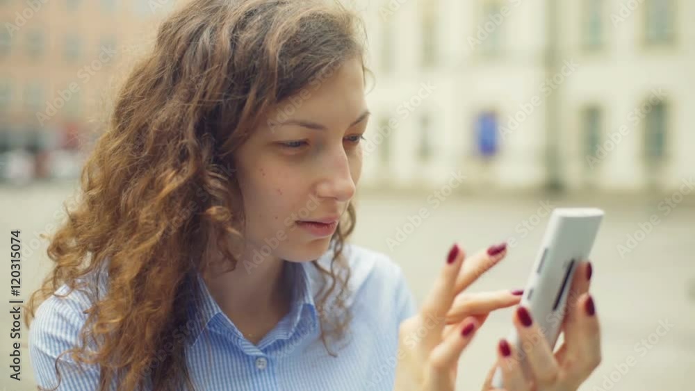 Girl browsing internet on smartphone while sitting on the square
Girl browsing internet on smartphone while sitting on the square