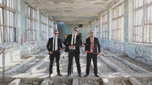 three criminals with weapons in an abandoned building