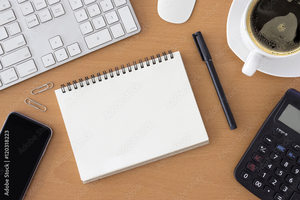 office workplace with keyboard, notepad, mouse, smartphont and coffee of cup on wooden table. over light office workplace with keyboard, notepad, mouse, smartphont and coffee of cup on wooden table. over light