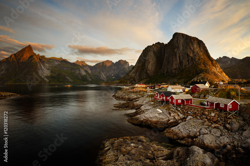 Red fishing huts of Hamnoy village with surrounding mountain pea