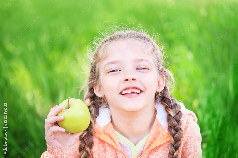 Sweet girl with a fallen toth holding an apple in her hand Sweet girl with a fallen toth holding an apple in her hand
