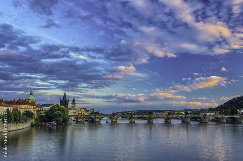 Blue coloured view on the Charles bridge over the Vltava river during sunset.