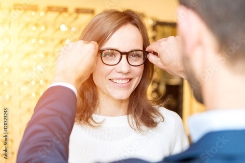 Fototapeta Naklejka Na Ścianę i Meble -  Young attractive  woman testing new glasses with optician