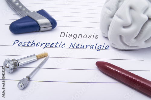 Figure of human brain, blue neurological reflex hammer, neurological needle and brush for test sensitivity and ballpoint pen lie on a paper form with a medical diagnosis of Postherpetic neuralgia  photo