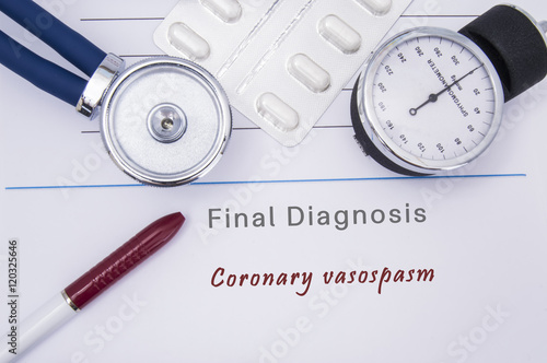 Paper medical form with a text diagnosis of Coronary vasospasm on which lie the stethoscope, blood pressure monitor, white tablets or pills in a blister pack and a red ballpoint pen  photo