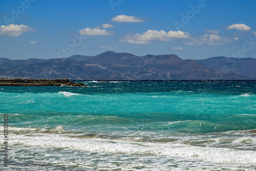 Waves breaking on sand beach coast of Crete island.