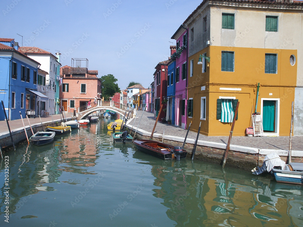 Obraz premium Canal in Burano, Italy. Burano is situated 7 kilometres (4 miles) from Venice. Burano is also known for its small, brightly painted houses, which are popular with artists