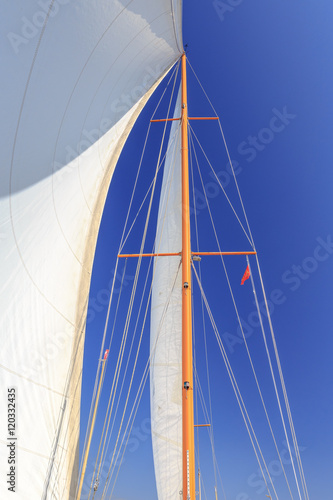 Segel und Mast eines Segelbootes unter blauem Himmel