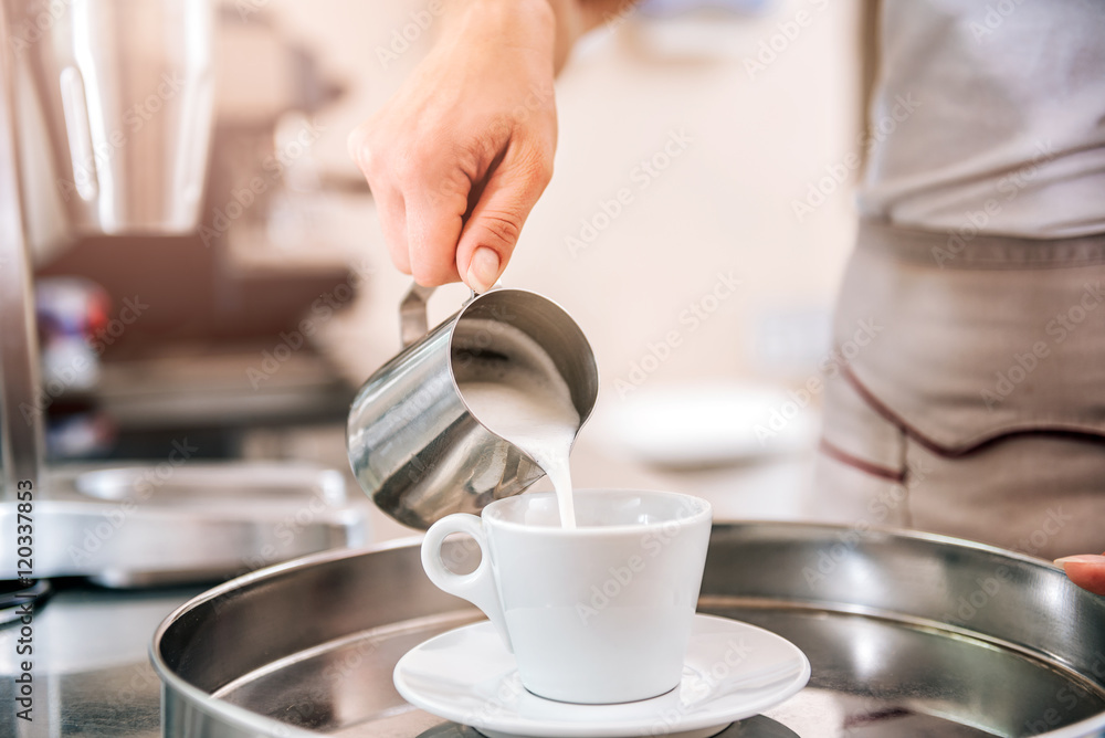 Woman pouring milk in coffee