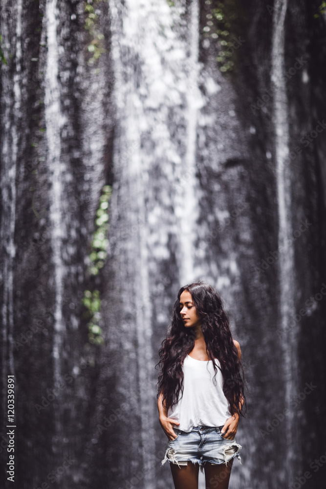 Beautiful brunette woman enjoying near waterfall Beautiful brunette woman enjoying near waterfall