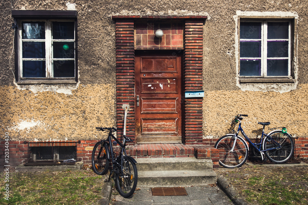 Fototapeta premium Bikes parked near the house with vintage wooden door