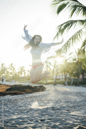 happy girl dancing and jumping on beach