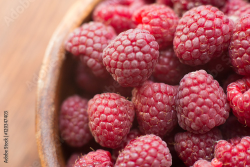 Macro photo of raspberry in wooden bowl  fresh berries close up  summer background