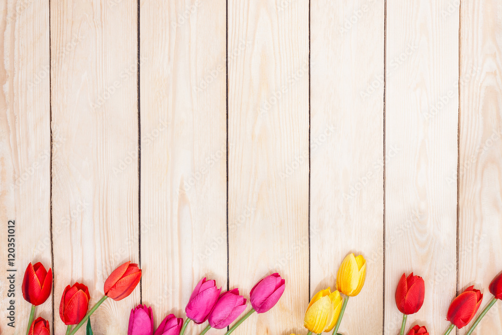 Pink, red, yelow, tulips on wooden background. Top view.
