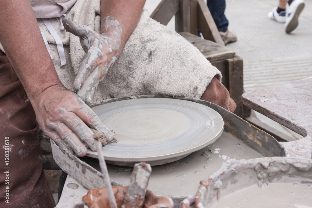 A male potter prepares his pottery wheel