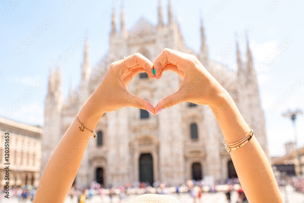 Fototapeta premium Hands in form of the heart on the famous Duomo cathedral backround in Milan.