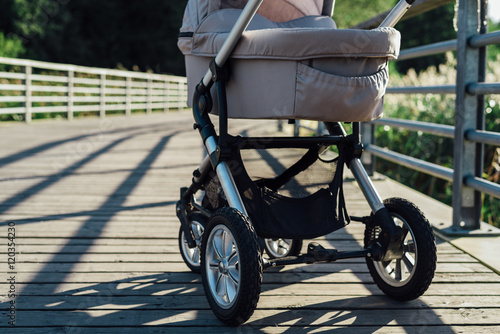 Fototapeta Baby stroller on running path in park