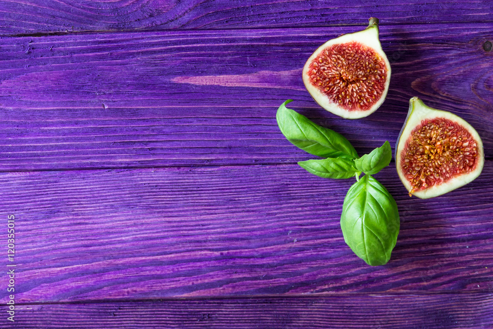 Figs and basil on wooden purple background. Layout with free text space