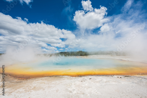 Rainbow pool in Black Sand Basin in Yellowstone National Park with orange and light blue colors with steam rising