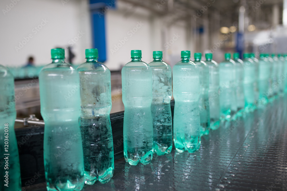 Water bottling line for processing and bottling pure mineral carbonated water into bottles. Selective focus.