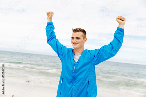 Young man in sport wear with outstretched arms