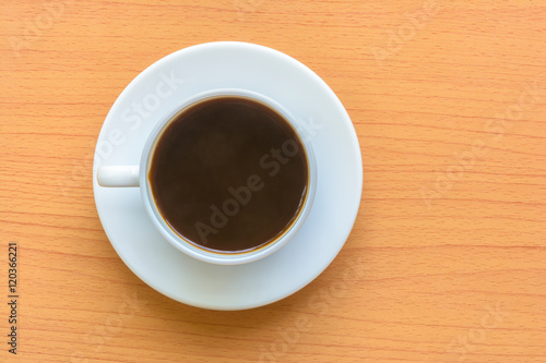 Black coffee in white cup on wooden table
