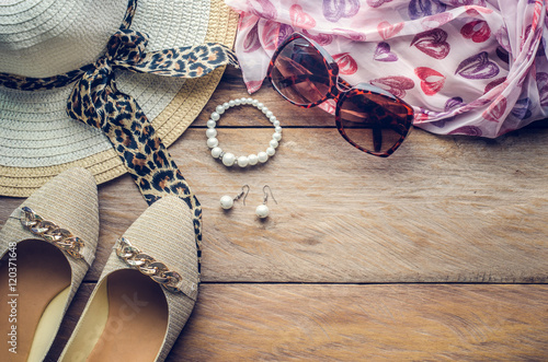 accessories for teenage girl on her vacation, hat, stylish for summer sunglasses, shoes and costume on wooden floor.