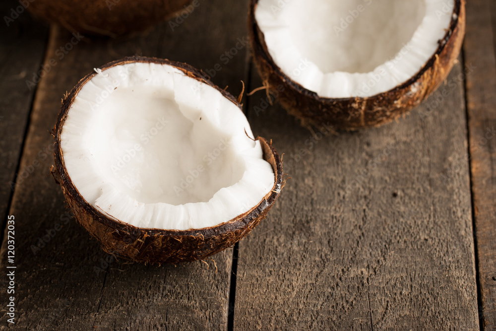 Ripe half cut coconut with milk on a wooden background Ripe half cut coconut with milk on a wooden background