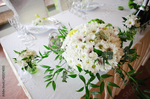 Wedding table decoration in white and green colors. Wedding floristry. Fresh mix