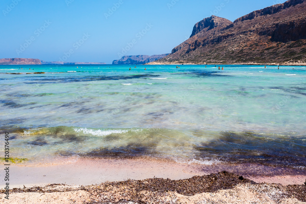 Sunbathing people on gritty beach of Balos lagoone on Crete. Greece.