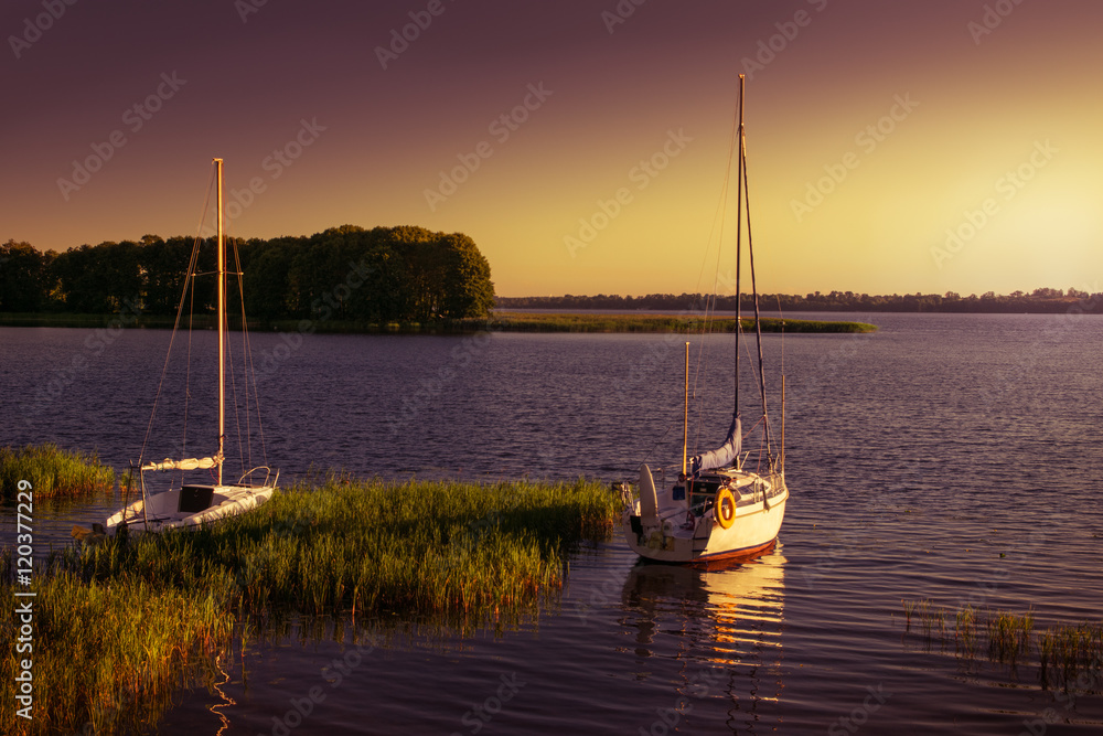 Yachts floating on the  waters of the polish lake. Early morning.