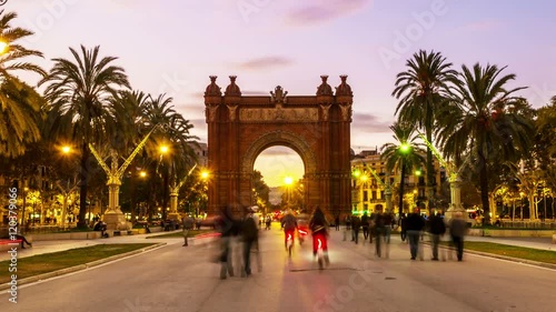 Arch of Triumph in Barcelona, Spain at night. Time-lapse of a sunset, motion blurred people, lights and illumination