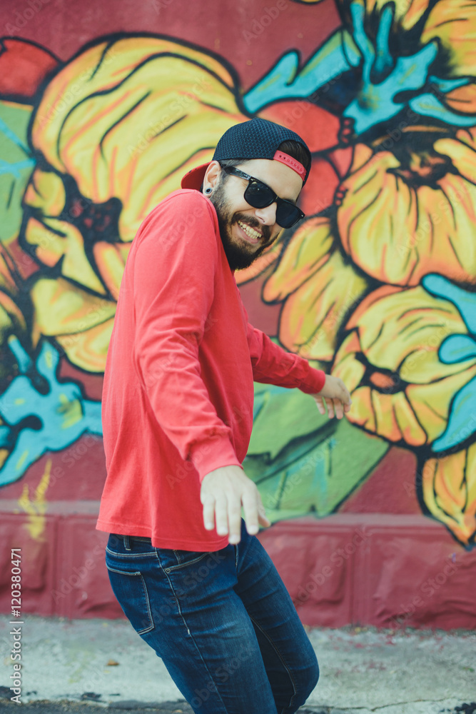 Obraz premium Young man dances with a graffiti in the background