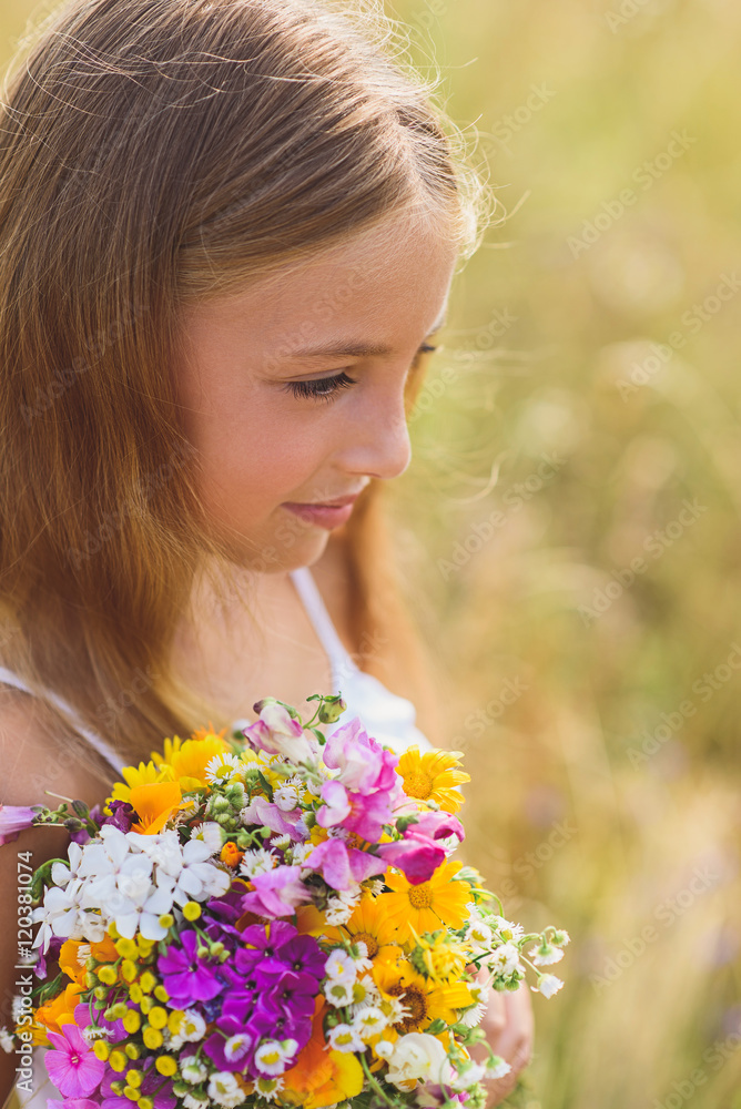 Dreamful child with flowers on field Dreamful child with flowers on field