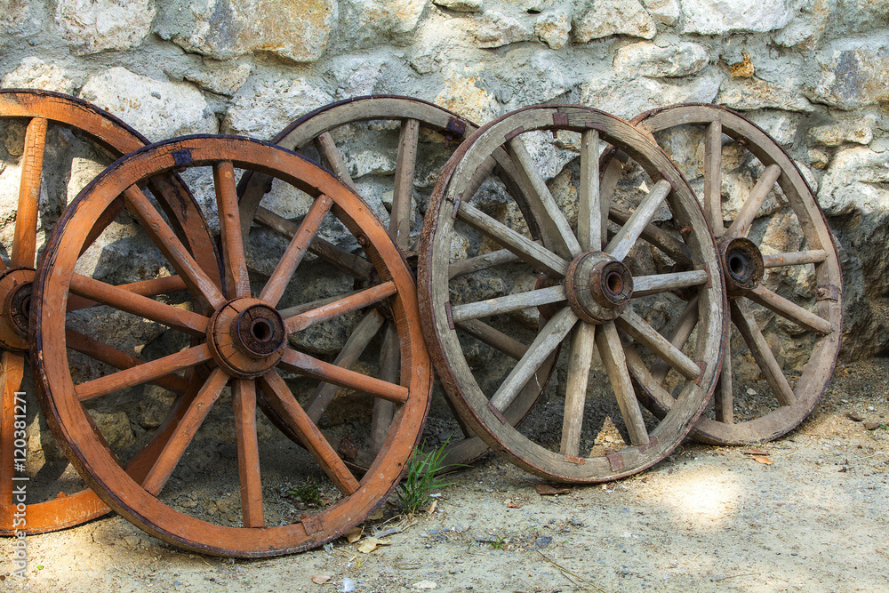 Some historic abandoned faded wooden cart wheels together
