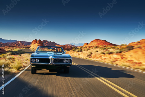 man driving vintage car through desert