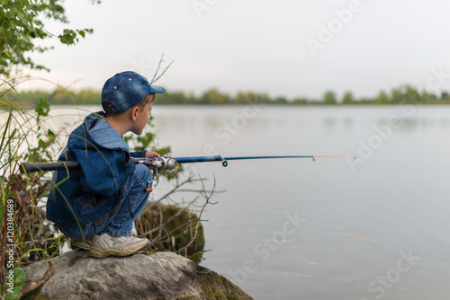 child on a summer fishing on the shore