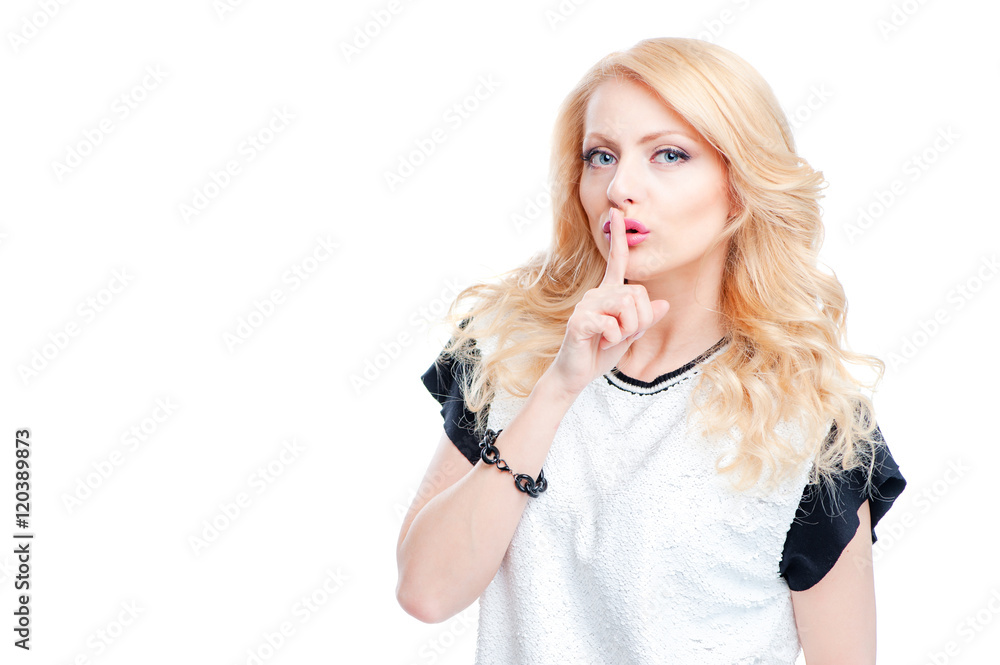 Keep silence! Attractive young blonde woman holding finger on lips and looking at camera while standing isolated on white background Keep silence! Attractive young blonde woman holding finger on lips and looking at camera while standing isolated on white background