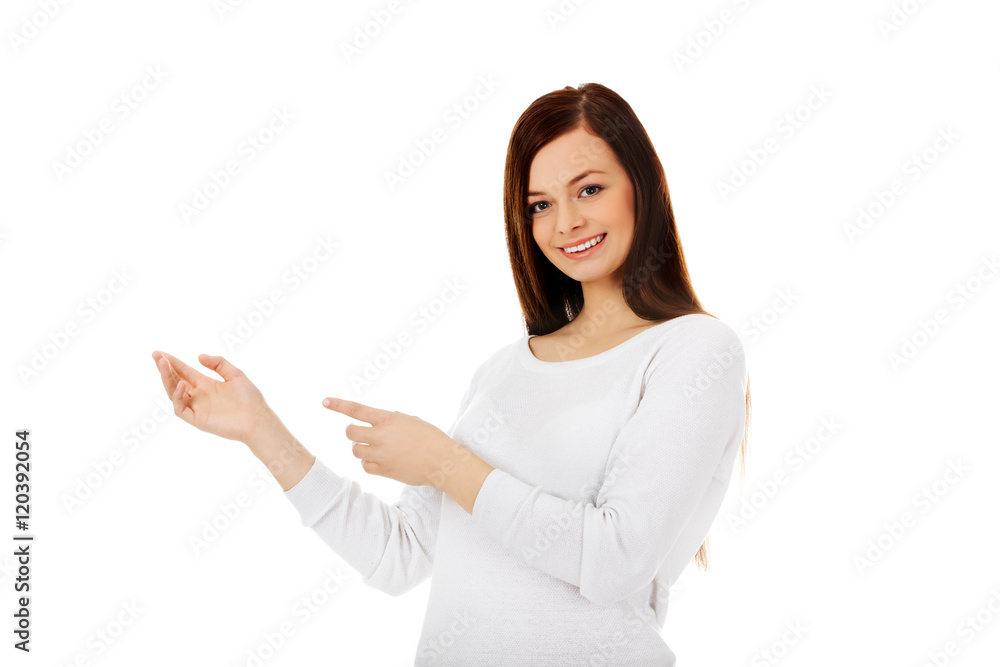 Smiling young woman shows something Smiling young woman shows something