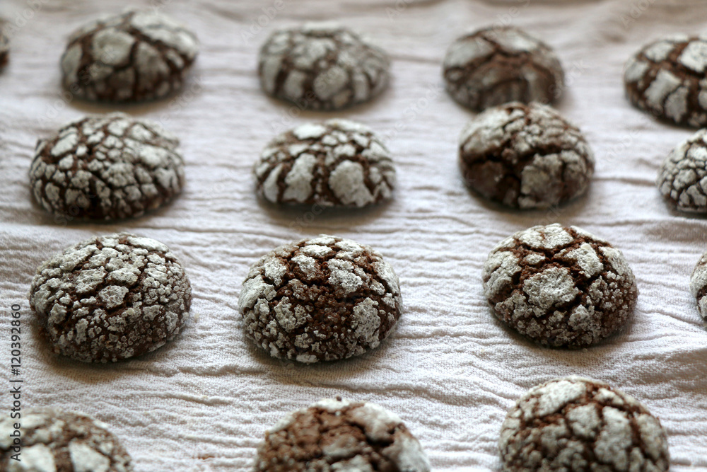 Chocolate crackle cookies organized on white napkin. Decorated with granulated and powdered sugar. Selective focus. Chocolate crackle cookies organized on white napkin. Decorated with granulated and powdered sugar. Selective focus.