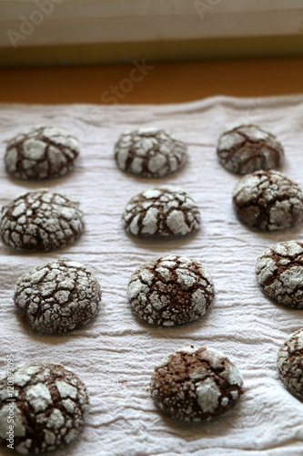 Chocolate crackle cookies organized on white napkin. Decorated with granulated and powdered sugar. Selective focus.