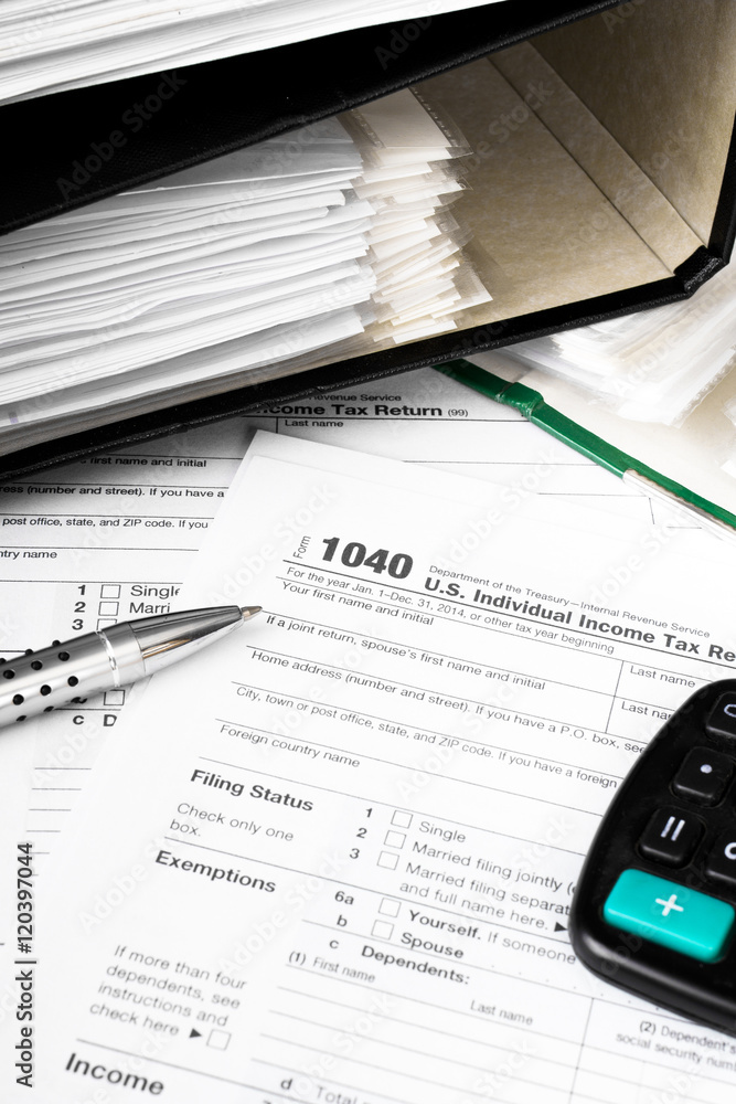 Close up U.S. Individual tax form 1040 with calculator and pen. Close up U.S. Individual tax form 1040 with calculator and pen.
