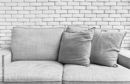 Grey linen sofa couch chair on white brick wall background